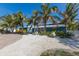 Charming blue home with lush tropical landscaping and circular brick paver driveway at 6201 Holmes Blvd, Holmes Beach, FL 34217