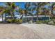 Charming blue home with lush tropical landscaping and circular brick paver driveway at 6201 Holmes Blvd, Holmes Beach, FL 34217