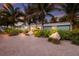 Charming single-story home featuring tropical landscaping, a gravel driveway, and serene curb appeal at sunset at 6201 Holmes Blvd, Holmes Beach, FL 34217