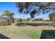 Expansive backyard with a serene pond, mature trees, and well-maintained landscaping at 6911 Stetson Street Cir, Sarasota, FL 34243