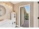 Bright bathroom with a modern vanity, a large round mirror, and access to an outdoor patio area at 6911 Stetson Street Cir, Sarasota, FL 34243