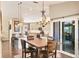 Charming dining area features stylish chandelier, wood floors, and sliding glass doors to the lanai at 6911 Stetson Street Cir, Sarasota, FL 34243