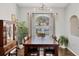 Dining area has a large table with dark wood furniture with large arched window providing natural light at 6911 Stetson Street Cir, Sarasota, FL 34243