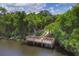 Aerial view of a wooden community dock nestled amidst lush trees and tranquil water at 6911 Stetson Street Cir, Sarasota, FL 34243