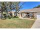 Inviting home featuring a well-kept lawn, mature landscaping, and a welcoming facade at 6911 Stetson Street Cir, Sarasota, FL 34243