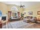 Spacious living room boasts high ceilings, a cozy fireplace, large window and comfortable seating at 6911 Stetson Street Cir, Sarasota, FL 34243