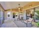 Relaxing screened-in patio with stylish furniture and scenic views of the landscaped backyard and water at 6911 Stetson Street Cir, Sarasota, FL 34243