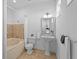 All-white bathroom featuring a tub with tile surround, pedestal sink with mirror, toilet, and tiled floors at 6919 Winners Cir, Lakewood Ranch, FL 34202