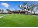 Beautiful exterior shot of the community clubhouse featuring mature trees, a sprawling lawn and inviting entrance at 6919 Winners Cir, Lakewood Ranch, FL 34202
