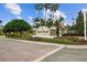 A brick paved street leads to the Quail Creek community sign with palm trees and lush landscaping at 6919 Winners Cir, Lakewood Ranch, FL 34202
