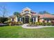 Stunning two-story home with a tile roof, manicured lawn, and lush landscaping under a clear blue sky at 6919 Winners Cir, Lakewood Ranch, FL 34202