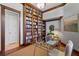 A cozy office featuring custom built-in bookshelves, trim, and hardwood floors at 6919 Winners Cir, Lakewood Ranch, FL 34202