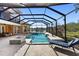 Relaxing screened pool area with a spa, fire pit, and a comfortable lounge chair overlooking the water at 6919 Winners Cir, Lakewood Ranch, FL 34202