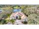 Stunning aerial view of home near lake featuring mature landscaping, tile roof, and brick paved driveway at 8116 Collingwood Ct, University Park, FL 34201