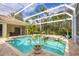 Inviting screened-in pool with adjacent spa, complemented by lush landscaping and brick-paver deck at 8121 Collingwood Ct, University Park, FL 34201