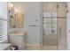 Glass enclosed shower with neutral tile, convenient bench and shelves, and dual shower heads at 8121 Collingwood Ct, University Park, FL 34201