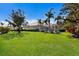 Backyard with a manicured lawn, mature landscaping, and screened in lanai at 8803 18Th Nw Ave, Bradenton, FL 34209