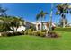 Landscaped front yard showcases a beige single-story home with tropical plants and bright green grass at 8803 18Th Nw Ave, Bradenton, FL 34209