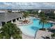 Community aerial view featuring a large pool with lounge areas, tables, and umbrellas at 12326 Blue Hill Trl, Bradenton, FL 34211