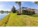 Well-manicured backyard leading to a serene lake, complete with lush landscaping at 12326 Blue Hill Trl, Bradenton, FL 34211
