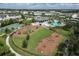 Aerial view of community playground, basketball court, pool, and dog park with well manicured landscaping at 12326 Blue Hill Trl, Bradenton, FL 34211