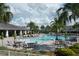 Relaxing community pool area with tables, chairs, umbrellas, and lush landscaping at 12326 Blue Hill Trl, Bradenton, FL 34211