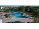 Beautiful community pool surrounded by lush greenery, lounge chairs, and umbrellas at 12326 Blue Hill Trl, Bradenton, FL 34211