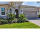 Close-up of a charming home's entrance with lush landscaping and a brick-paved driveway at 12326 Blue Hill Trl, Bradenton, FL 34211