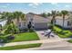 Charming single-Gathering home boasts a well-kept lawn, brick driveway, and decorative palm trees at 12326 Blue Hill Trl, Bradenton, FL 34211