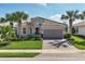 Inviting single-story home with manicured lawn, lovely landscaping, and a brick-paved driveway at 12326 Blue Hill Trl, Bradenton, FL 34211