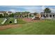 View of playground equipment including slides, swing sets and climbing equipment with grassy lawn at 12326 Blue Hill Trl, Bradenton, FL 34211
