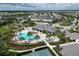 Aerial view of community pool, clubhouse, tennis court, and playground in lush, landscaped neighborhood at 12326 Blue Hill Trl, Bradenton, FL 34211