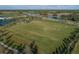 Expansive community sports field featuring manicured lawns, playground, adjacent lake, and scenic walking paths at 12326 Blue Hill Trl, Bradenton, FL 34211
