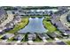 Aerial view of a community with a pond and many houses with lawns and mature trees at 12716 Dusty Trail Dr, Sarasota, FL 34238