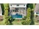 Aerial view of a home's backyard showcasing a screened-in pool, stone patio, lush landscaping, and a well-manicured lawn at 12716 Dusty Trail Dr, Sarasota, FL 34238