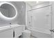 This bathroom includes a tub, toilet, sink, a mirror, and unique wall tiles at 12716 Dusty Trail Dr, Sarasota, FL 34238