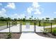 A dog park is securely fenced with separate areas for large and small dogs, surrounded by lush landscaping and sunny skies at 12716 Dusty Trail Dr, Sarasota, FL 34238