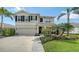 Two-story home featuring a manicured lawn, lush landscaping, and a two-car garage at 12716 Dusty Trail Dr, Sarasota, FL 34238