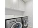 This laundry room features a washer, dryer, and storage cabinets at 12716 Dusty Trail Dr, Sarasota, FL 34238