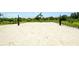 Community sand volleyball court surrounded by lush greenery and tropical landscaping at 12716 Dusty Trail Dr, Sarasota, FL 34238