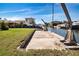 Canal-front property featuring a concrete dock area with a crane and green lawn at 1541 Shelburne Ln, Sarasota, FL 34231