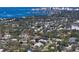 An aerial view shows a two-story home surrounded by trees, close to the ocean, and a city skyline at 1543 Eastbrook Dr, Sarasota, FL 34231