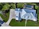 Aerial view of a home with a metal roof, paver driveway, and lush landscaping in a well-kept yard at 1543 Eastbrook Dr, Sarasota, FL 34231