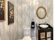 Powder room with decorative wallpaper, ornate mirror, and modern fixtures at 1543 Eastbrook Dr, Sarasota, FL 34231