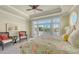 Bright bedroom featuring large windows, tray ceilings, comfortable seating, and a floral-patterned bedspread at 1543 Eastbrook Dr, Sarasota, FL 34231