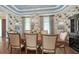 Formal dining room with designer wallpaper, tray ceiling, chandelier, and hardwood floors at 1543 Eastbrook Dr, Sarasota, FL 34231