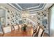 Formal dining room with designer wallpaper, tray ceiling, chandelier, and hardwood floors at 1543 Eastbrook Dr, Sarasota, FL 34231