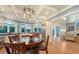Bright kitchen and breakfast nook featuring a modern chandelier, stainless appliances, and hardwood floors at 1543 Eastbrook Dr, Sarasota, FL 34231