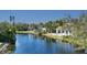 Scenic lake view with lush landscaping, a screened in porch, and a variety of palm trees at 1543 Eastbrook Dr, Sarasota, FL 34231