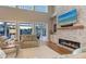 Bright living room featuring a stone fireplace, a large television, hardwood floors, and views of the pool at 1543 Eastbrook Dr, Sarasota, FL 34231